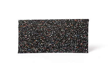 Abgebildet ist eine Matte aus schwarzem Gummigranulat mit bunten Farbtupfern.