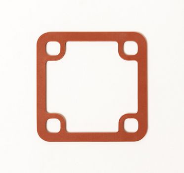 Eine rechteckige, rote Dichtung aus Kunststoff mit vier runden Aussparungen an den Ecken ist auf weißem Grund abgebildet.