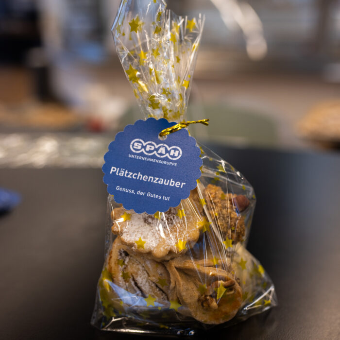 Eine von Späh-Mitarbeitern gebackene Plätzchentüte steht auf dem Tisch. Die Tüte hat eine Aufschrift mit "Plätzchenzauber".