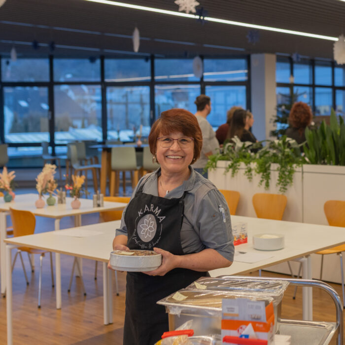 Eine Späh-Mitarbeiterin aus der Kantine stellt die Zutaten für das gemeinsame Backen der Mitarbeiter auf die Tische.